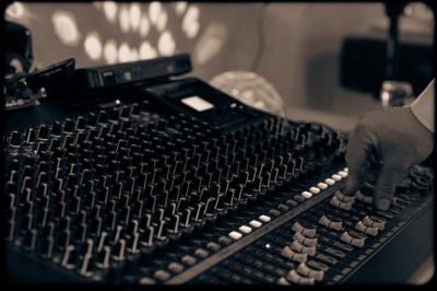 Un homme en costume bleu tient un saxophone dans un intérieur lumineux avec de grandes fenêtres.