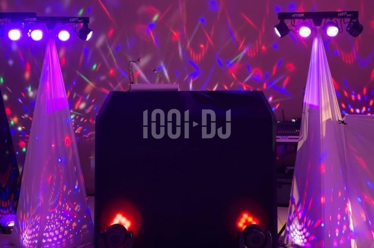 Installation de matériel de sonorisation et éclairage coloré avec projecteurs et effets lumineux dans une salle.