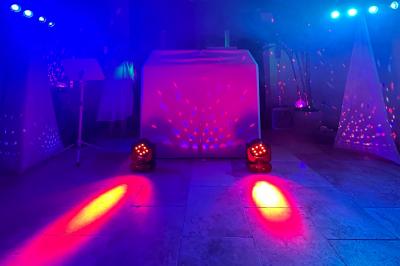 Un homme en costume bleu tient un saxophone dans un intérieur lumineux avec de grandes fenêtres.