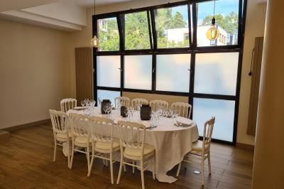 Salle décorée avec des ballons roses, éclairage violet, deux personnes marchant au centre, tables hautes et chaises…