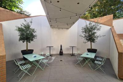 Salle décorée avec des ballons roses, éclairage violet, deux personnes marchant au centre, tables hautes et chaises…