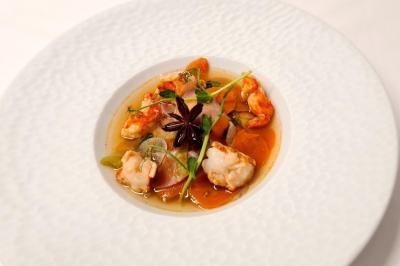 Salle décorée avec des ballons roses, éclairage violet, deux personnes marchant au centre, tables hautes et chaises…