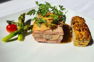 Salle décorée avec des ballons roses, éclairage violet, deux personnes marchant au centre, tables hautes et chaises…