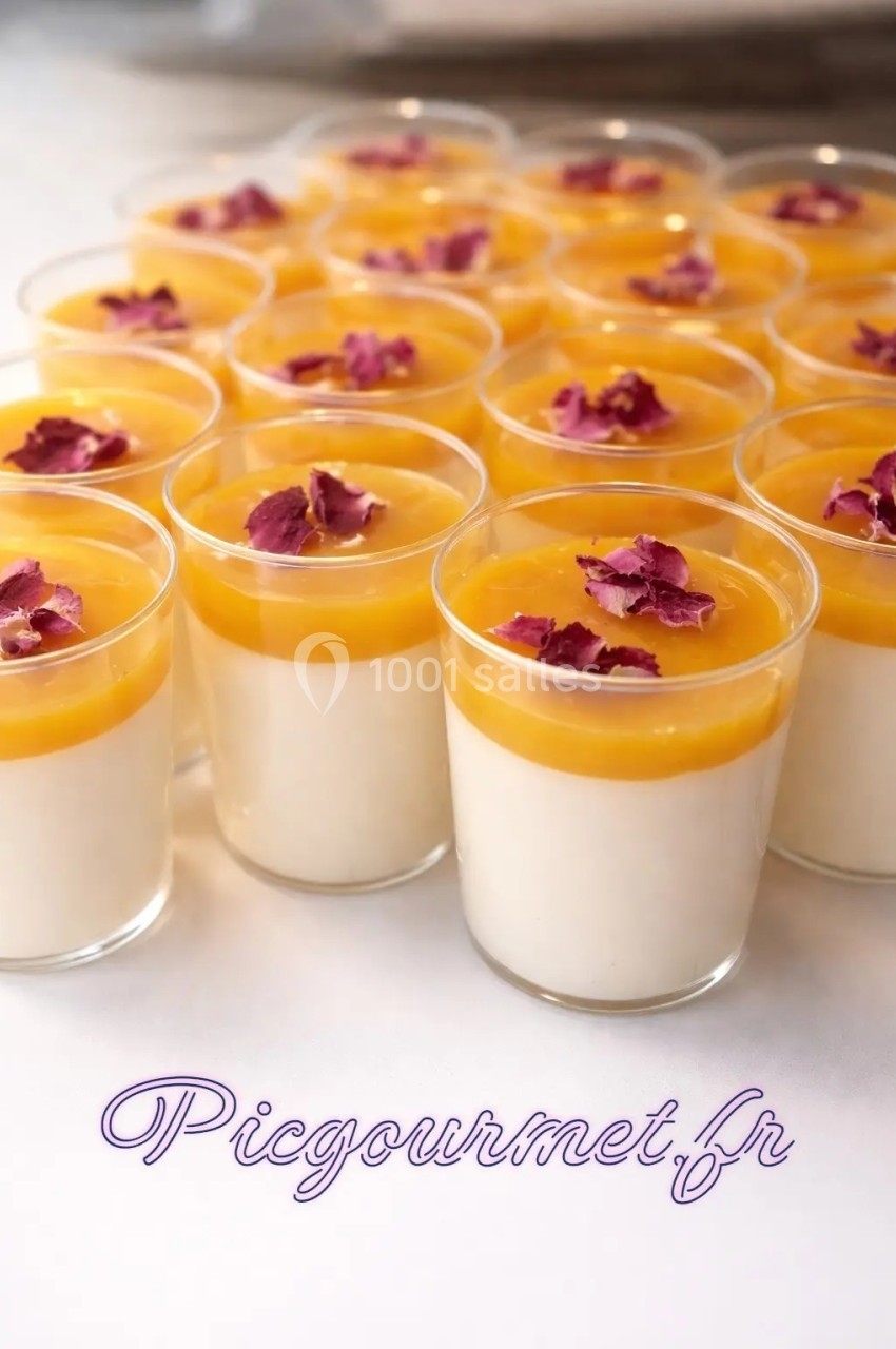 Verrines de panna cotta garnies de coulis jaune et décorées de pétales de fleurs séchées.