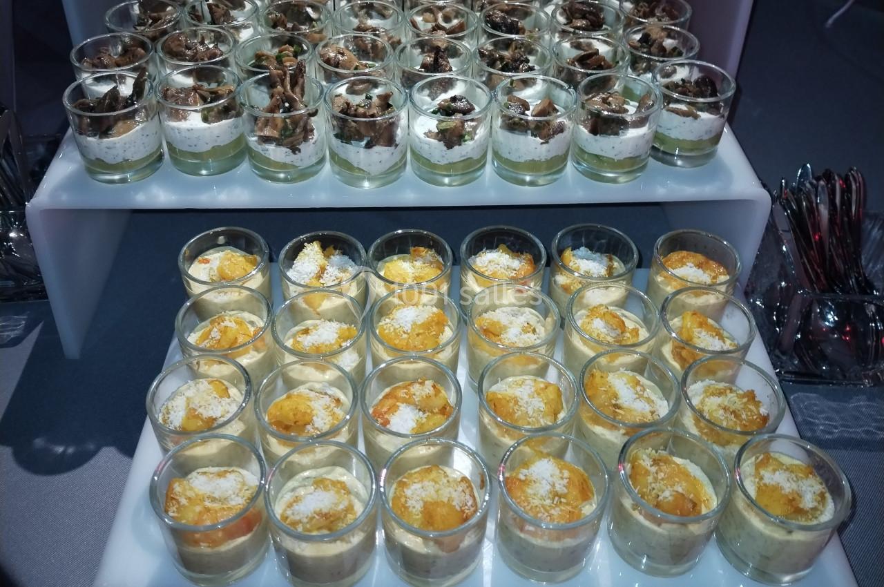 Plateau de verrines salées variées, disposées en rangées, avec des ingrédients colorés et des textures différentes.