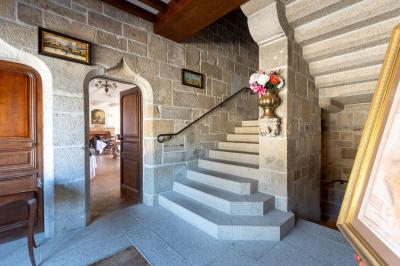 Façade éclairée d'un grand bâtiment en pierre de style ancien, entouré d'une pelouse, de nuit.