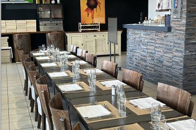 Miniature Location salle Lyon 9 (Rhône) - Le Petit Marché d'Une Faim d'Apprendre #15 Salle lumineuse avec grandes baies vitrées, tables en bois et vue sur une rue calme bordée de bâtiments.