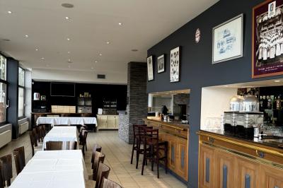 Miniature Location salle Lyon 9 (Rhône) - Le Petit Marché d'Une Faim d'Apprendre #9 Salle lumineuse avec grandes baies vitrées, tables en bois et vue sur une rue calme bordée de bâtiments.