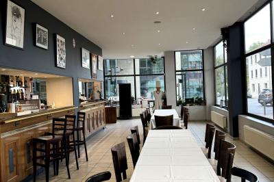 Miniature Location salle Lyon 9 (Rhône) - Le Petit Marché d'Une Faim d'Apprendre #7 Salle lumineuse avec grandes baies vitrées, tables en bois et vue sur une rue calme bordée de bâtiments.