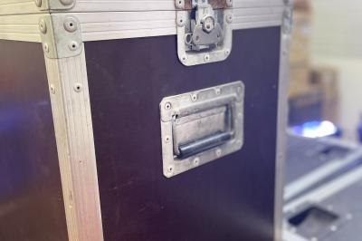 Miniature Ouest Spectacles et Techiques #3 Enceintes de sonorisation empilées dans une configuration de type line array, partiellement couvertes par des housses.