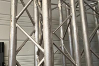 Miniature Ouest Spectacles et Techiques #5 Enceintes de sonorisation empilées dans une configuration de type line array, partiellement couvertes par des housses.