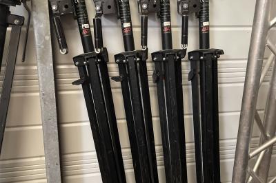 Enceintes de sonorisation empilées avec des grilles métalliques noires et une housse de protection partiellement visible.