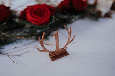 Costume de mariage bleu foncé avec chemise blanche et nœud papillon floral, suspendu sur un cintre gravé.