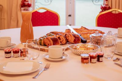Costume de mariage bleu foncé avec chemise blanche et nœud papillon floral, suspendu sur un cintre gravé.