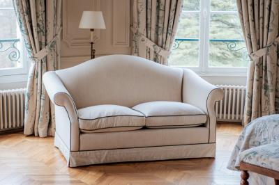 Costume de mariage bleu foncé avec chemise blanche et nœud papillon floral, suspendu sur un cintre gravé.