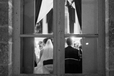 Costume de mariage bleu foncé avec chemise blanche et nœud papillon floral, suspendu sur un cintre gravé.