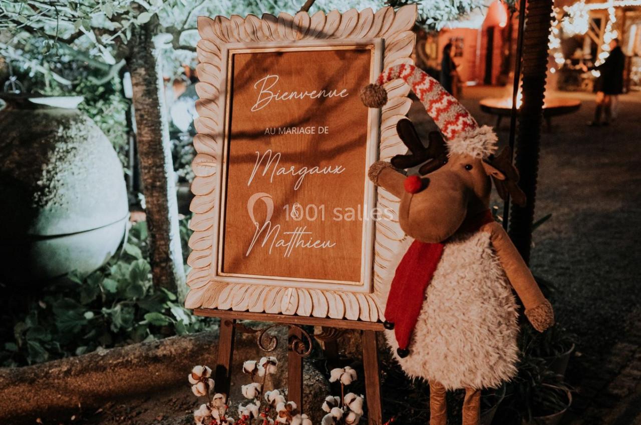 Panneau de bienvenue pour un mariage, décoré avec un renne en peluche et des éléments festifs.