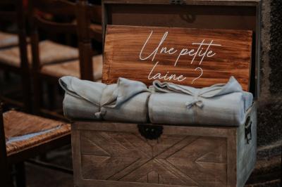 Costume de mariage bleu foncé avec chemise blanche et nœud papillon floral, suspendu sur un cintre gravé.