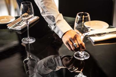 Miniature Location salle Paris 19 (Paris) - L'Envol de la Philharmonie #16 Un barman verse un liquide sombre dans un verre à cocktail rempli d'une boisson mousseuse.