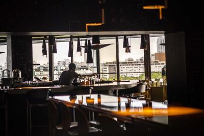 Miniature Location salle Paris 19 (Paris) - L'Envol de la Philharmonie #9 Un barman verse un liquide sombre dans un verre à cocktail rempli d'une boisson mousseuse.