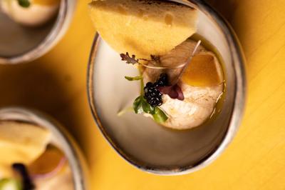 Miniature Location salle Paris 19 (Paris) - L'Envol de la Philharmonie #23 Un barman verse un liquide sombre dans un verre à cocktail rempli d'une boisson mousseuse.