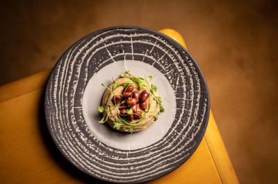 Miniature Location salle Paris 19 (Paris) - L'Envol de la Philharmonie #32 Un barman verse un liquide sombre dans un verre à cocktail rempli d'une boisson mousseuse.