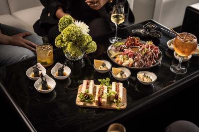 Miniature Location salle Paris 19 (Paris) - L'Envol de la Philharmonie #34 Un barman verse un liquide sombre dans un verre à cocktail rempli d'une boisson mousseuse.