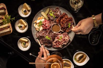 Miniature Location salle Paris 19 (Paris) - L'Envol de la Philharmonie #37 Un barman verse un liquide sombre dans un verre à cocktail rempli d'une boisson mousseuse.