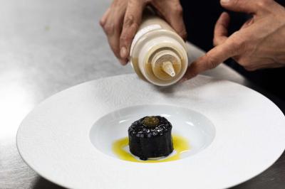 Miniature Location salle Paris 19 (Paris) - L'Envol de la Philharmonie #43 Un barman verse un liquide sombre dans un verre à cocktail rempli d'une boisson mousseuse.