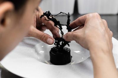 Miniature Location salle Paris 19 (Paris) - L'Envol de la Philharmonie #45 Un barman verse un liquide sombre dans un verre à cocktail rempli d'une boisson mousseuse.