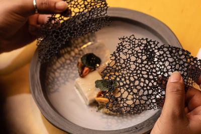 Miniature Location salle Paris 19 (Paris) - L'Envol de la Philharmonie #48 Un barman verse un liquide sombre dans un verre à cocktail rempli d'une boisson mousseuse.