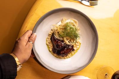 Miniature Location salle Paris 19 (Paris) - L'Envol de la Philharmonie #49 Un barman verse un liquide sombre dans un verre à cocktail rempli d'une boisson mousseuse.