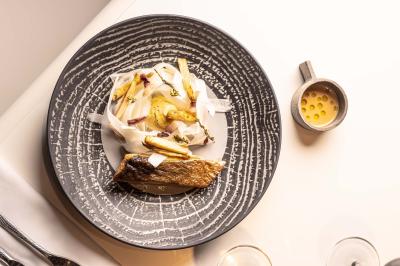 Miniature Location salle Paris 19 (Paris) - L'Envol de la Philharmonie #53 Un barman verse un liquide sombre dans un verre à cocktail rempli d'une boisson mousseuse.