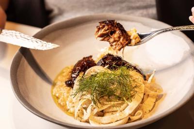 Miniature Location salle Paris 19 (Paris) - L'Envol de la Philharmonie #54 Un barman verse un liquide sombre dans un verre à cocktail rempli d'une boisson mousseuse.