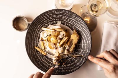 Miniature Location salle Paris 19 (Paris) - L'Envol de la Philharmonie #55 Un barman verse un liquide sombre dans un verre à cocktail rempli d'une boisson mousseuse.