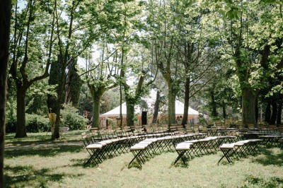 Deux fauteuils en cuir disposés près d'un poêle à bois dans une pièce au mur en bois décorée de cadres et d'une tête d'ours.