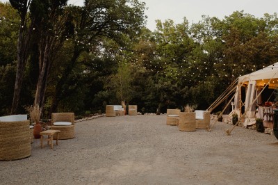 Deux fauteuils en cuir disposés près d'un poêle à bois dans une pièce au mur en bois décorée de cadres et d'une tête d'ours.