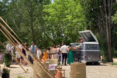 Deux fauteuils en cuir disposés près d'un poêle à bois dans une pièce au mur en bois décorée de cadres et d'une tête d'ours.