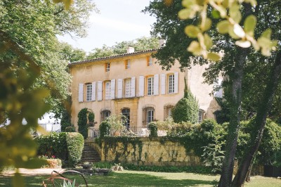 Deux fauteuils en cuir disposés près d'un poêle à bois dans une pièce au mur en bois décorée de cadres et d'une tête d'ours.