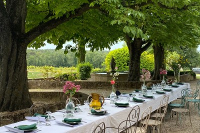Deux fauteuils en cuir disposés près d'un poêle à bois dans une pièce au mur en bois décorée de cadres et d'une tête d'ours.