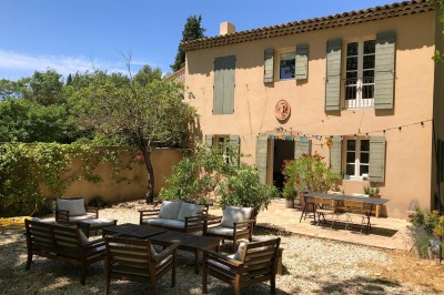 Deux fauteuils en cuir disposés près d'un poêle à bois dans une pièce au mur en bois décorée de cadres et d'une tête d'ours.