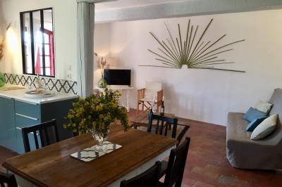 Deux fauteuils en cuir disposés près d'un poêle à bois dans une pièce au mur en bois décorée de cadres et d'une tête d'ours.