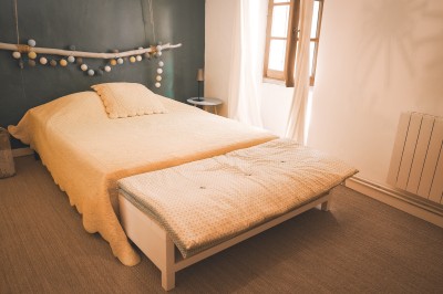 Deux fauteuils en cuir disposés près d'un poêle à bois dans une pièce au mur en bois décorée de cadres et d'une tête d'ours.
