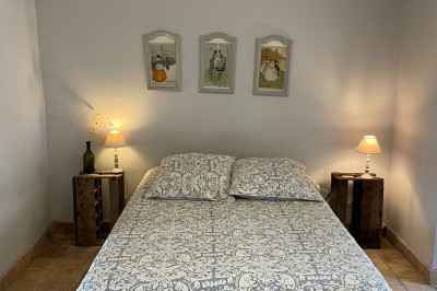 Deux fauteuils en cuir disposés près d'un poêle à bois dans une pièce au mur en bois décorée de cadres et d'une tête d'ours.