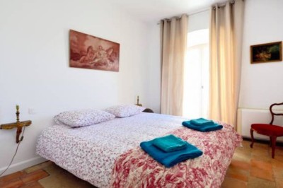 Deux fauteuils en cuir disposés près d'un poêle à bois dans une pièce au mur en bois décorée de cadres et d'une tête d'ours.