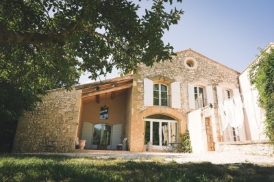 Deux fauteuils en cuir disposés près d'un poêle à bois dans une pièce au mur en bois décorée de cadres et d'une tête d'ours.