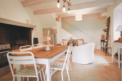 Deux fauteuils en cuir disposés près d'un poêle à bois dans une pièce au mur en bois décorée de cadres et d'une tête d'ours.