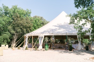 Deux fauteuils en cuir disposés près d'un poêle à bois dans une pièce au mur en bois décorée de cadres et d'une tête d'ours.