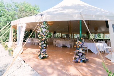 Deux fauteuils en cuir disposés près d'un poêle à bois dans une pièce au mur en bois décorée de cadres et d'une tête d'ours.