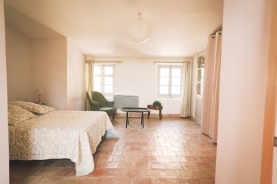 Deux fauteuils en cuir disposés près d'un poêle à bois dans une pièce au mur en bois décorée de cadres et d'une tête d'ours.